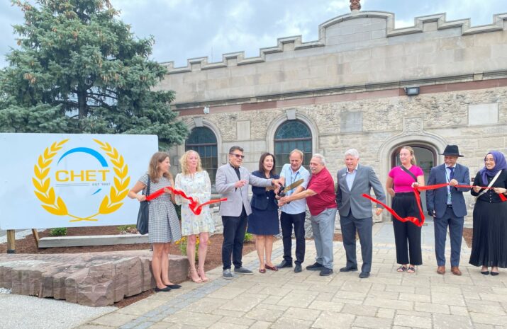 People standing and cutting a ribbon during an inauguration ceremony