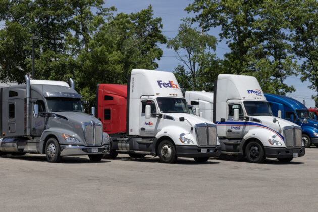 Kenworth Semi Tractor Trailer Big Rig Trucks in various customer livery at a dealership. Kenworth is owned by PACCAR.