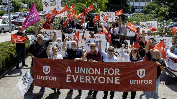 A diverse group of individuals at a union rally, holding signs and a banner that reads "Union for Everyone."