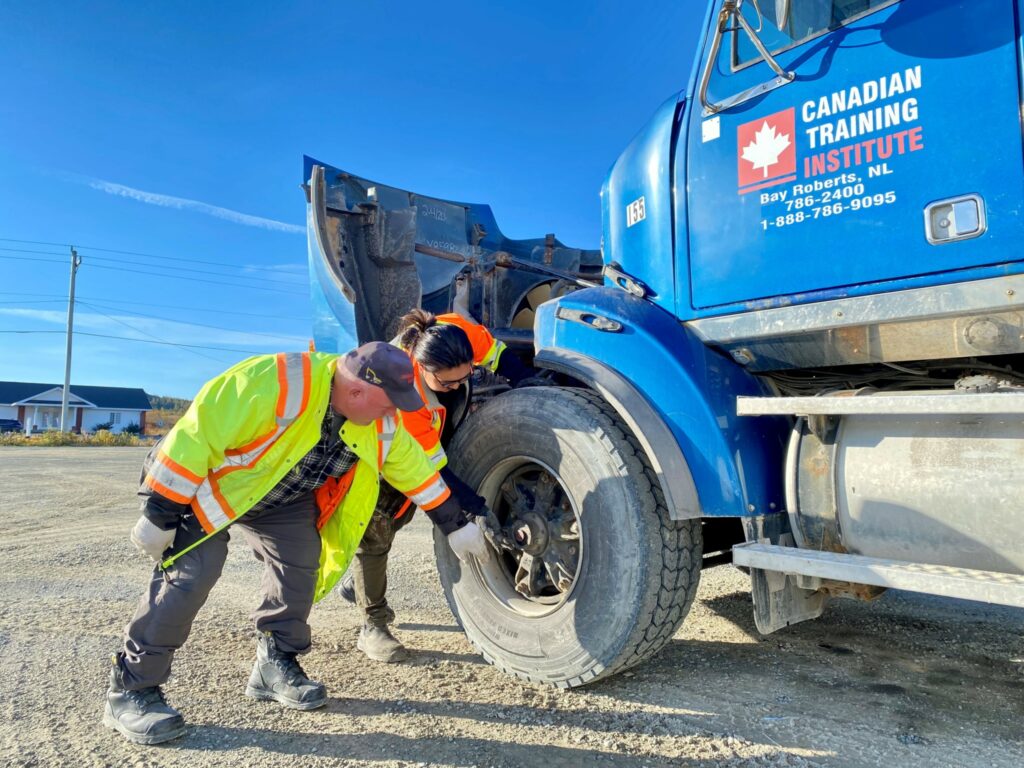 A student inspects a tire during a pre-trip inspection