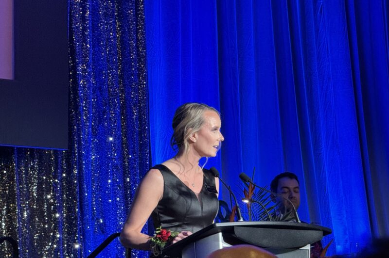 Stacey Large photo -- she is at the podium delivering a speech