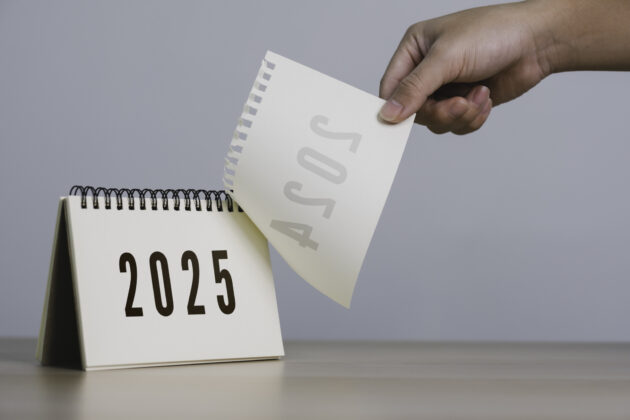 A person’s hand is pulling a calendar from 2024 to 2025. 2025 Happy New year background. Setup objective target business cost and budget planning of new year concept. alternate text for this image