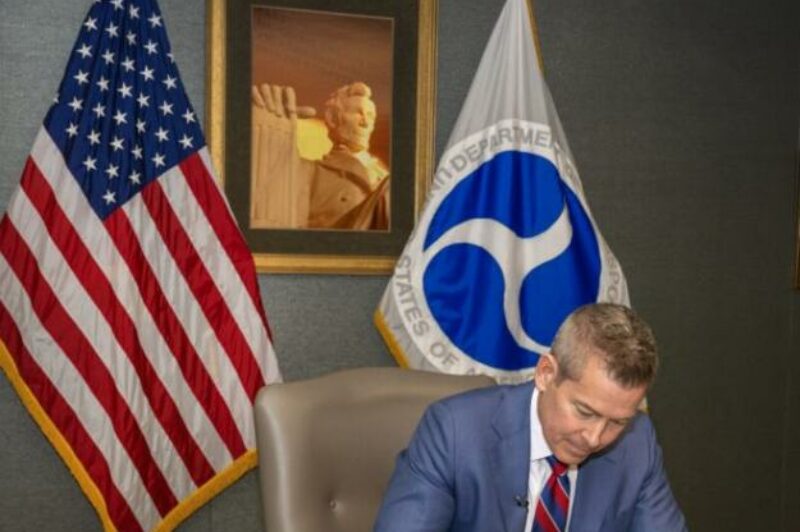 Photo of Duffy signing his first memo