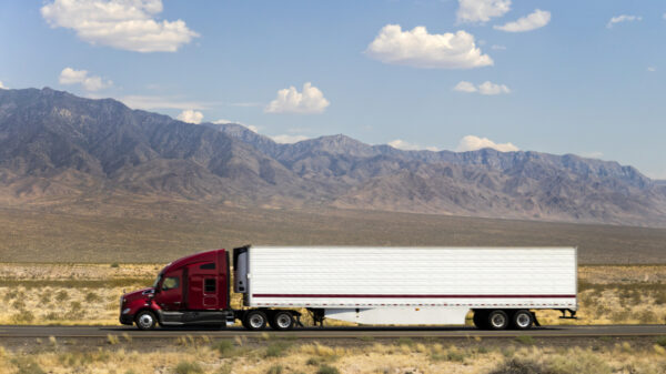 Fast and Powerful Heavy-Lift Modern Semi Truck Speeding on Highway, California, USA alternate text for this image