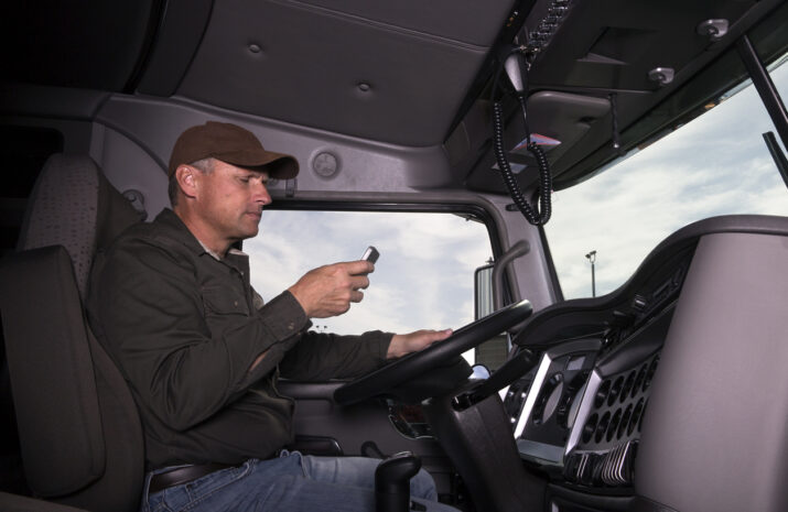 A truck driver texts while behind the wheel