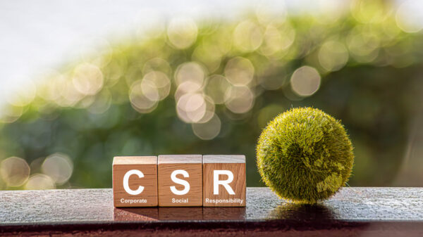 CSR (coporate social responsibility). words CSR on a woodblock and green world on a green background It is an idea for Corporate social responsibility and society activity concept. alternate text for this image