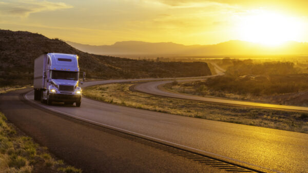 18-wheeler tractor-trailer truck and US highway 70 at sunset near Tularosa, New Mexico