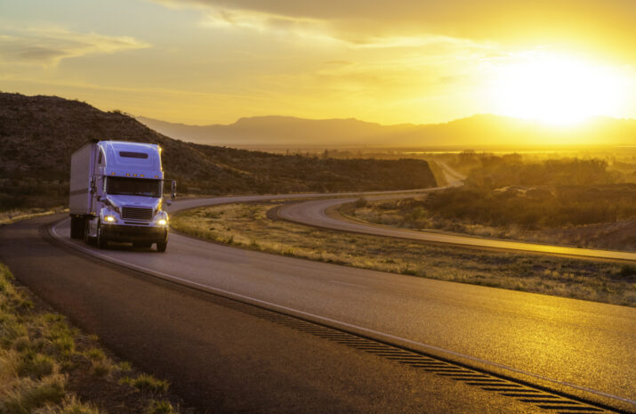 18-wheeler tractor-trailer truck and US highway 70 at sunset near Tularosa, New Mexico