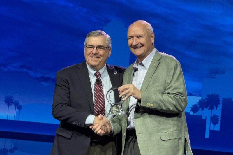 Jim Ward and John Culp on stage shaking hands