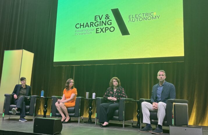 Three panelists and moderator sitting on stage during EV and Charging Expo 2025