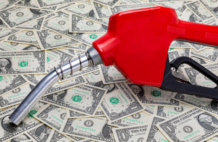 Gasoline fuel nozzle and cash money. Gas price, tax, ethanol and fossil fuel concept