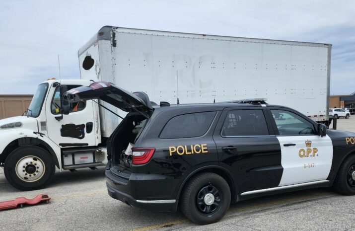 Picture of a police cruiser in front of truck