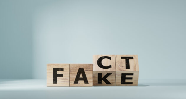 Flipping Wooden cube block for change fake to fact , news and social media concept. alternate text for this image