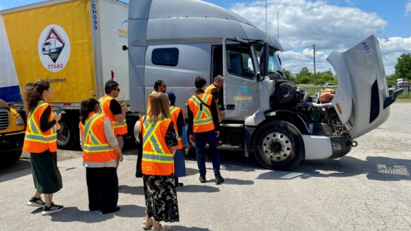 People with high visibility gear standing around a truck.