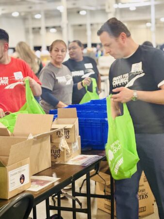 People packing food from boxes into bags