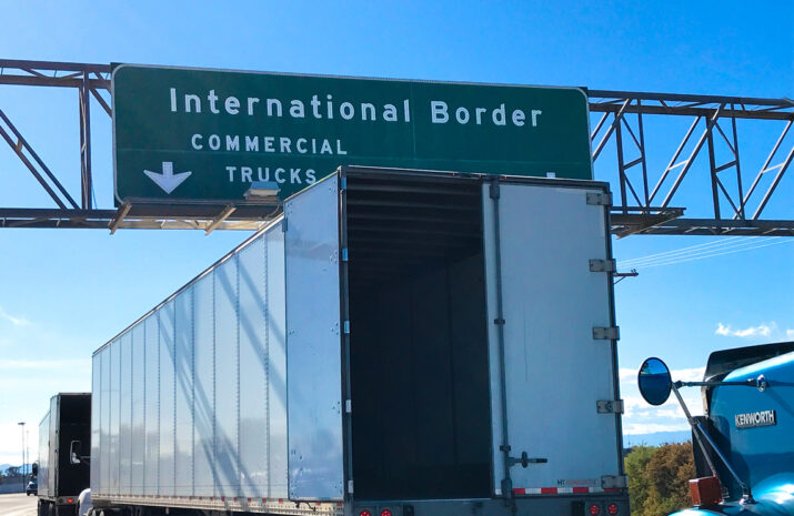 Calexico, CA: Trucks awaiting inspection at the US-Mexico border crossing at Calexico in southern California; one truck has its back door open.