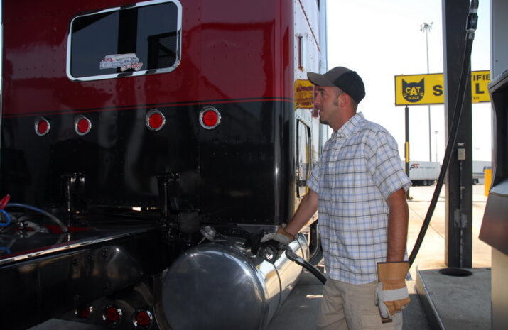 a truck driver fueling a truck