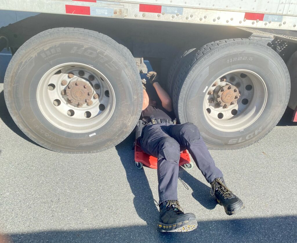 A police officer squeezes between tires