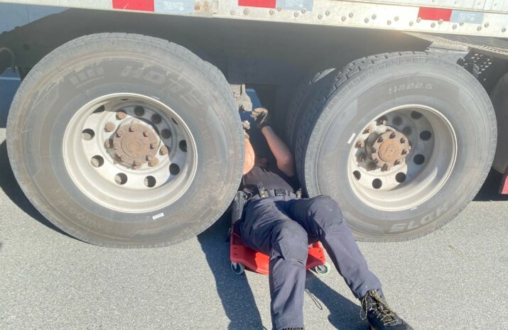 A police officer squeezes between tires