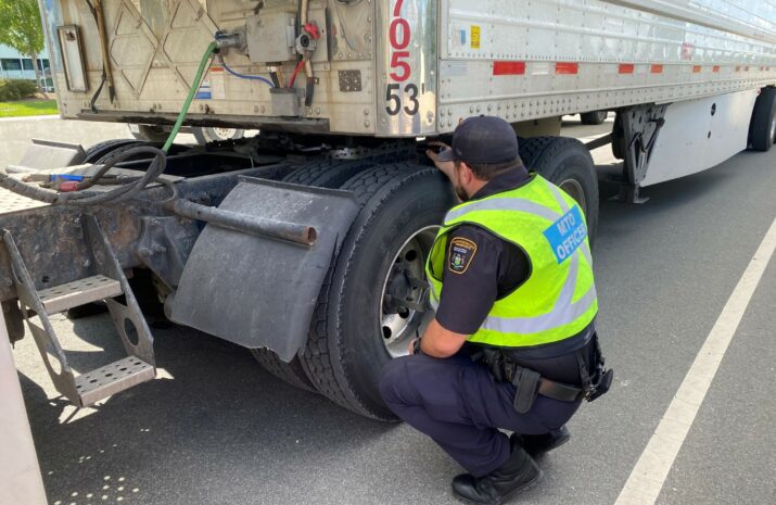An MTO officer inspects a tire