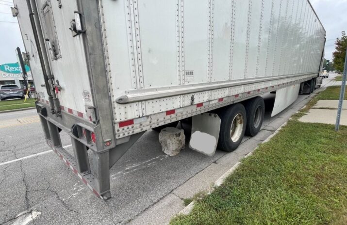 Picture of a tractor trailer dragging an armor stone