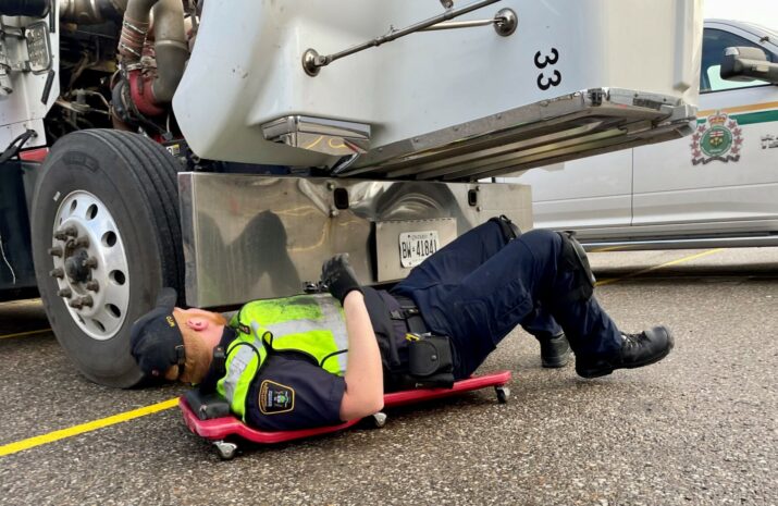 An officer inspecting a truck