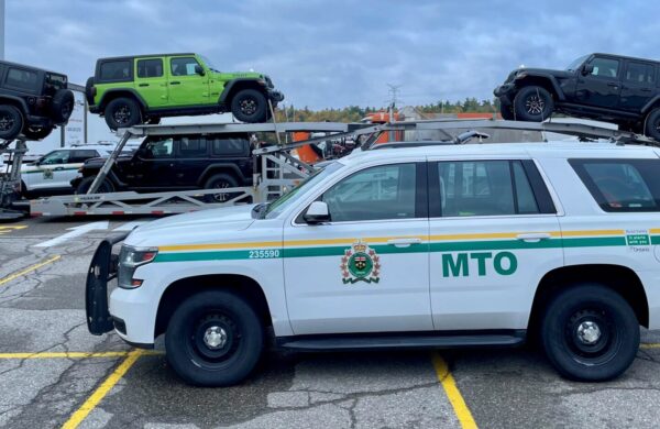 An MTO truck in the foreground and a car hauler with Jeeps in the background