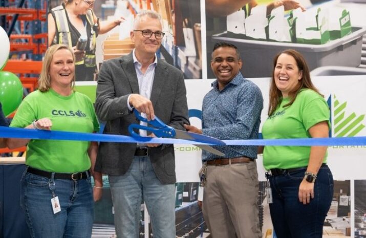 People smile during a ribbon-cutting ceremony