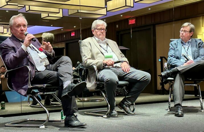 Picture of three men sitting on a stage