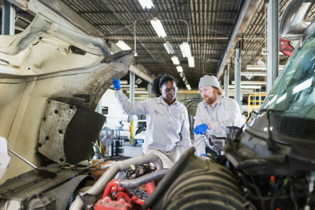 Technicians repair an engine.