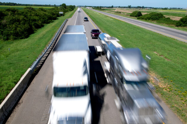 "Motion-blurred 18-wheelers zipping down Interstate 40 in east Arkansas, USA."