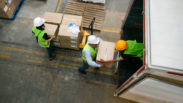 Group of warehouse workers loading a truck with boxes alternate text for this image