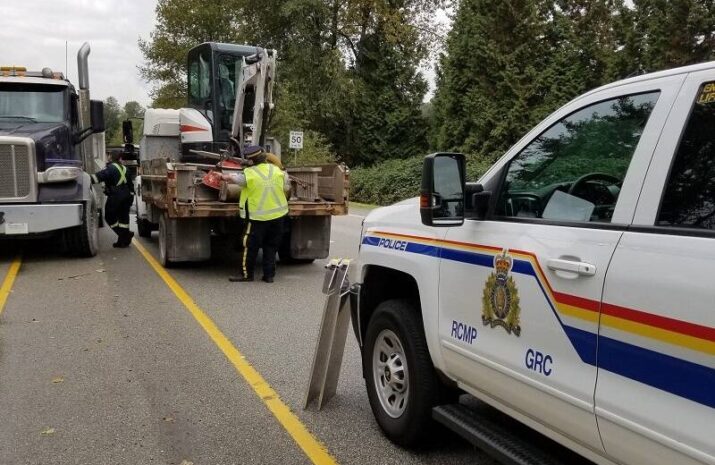 Officer inspecting trucks by the side of the road