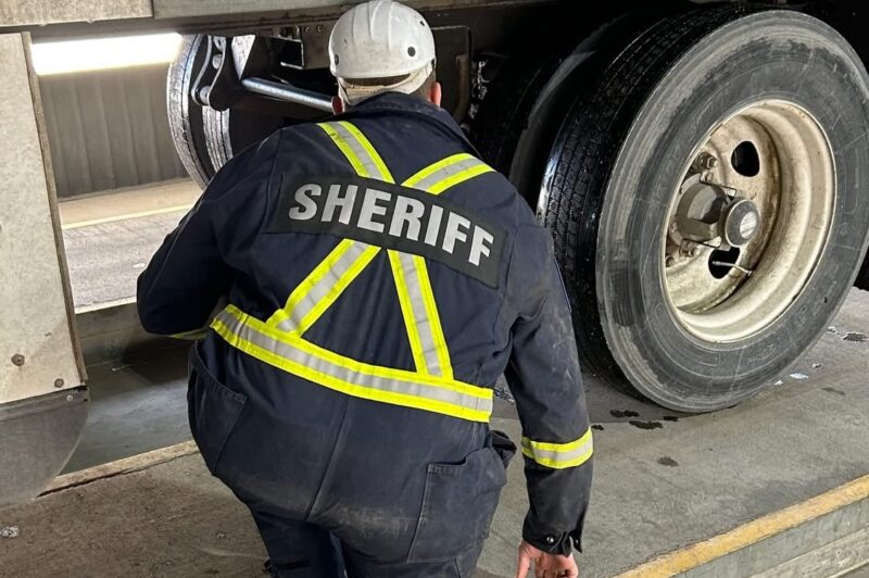 Picture of an Alberta Sheriff inspecting a truck