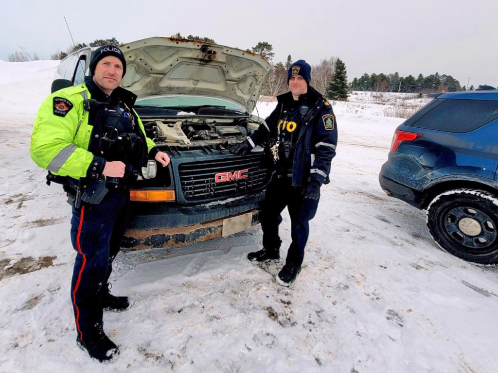 Picture of officers in front of a pick up truck