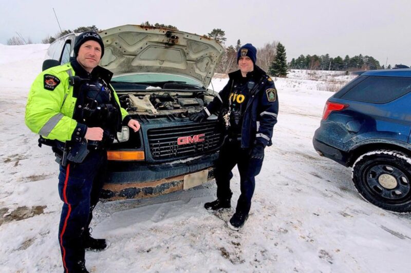 Picture of officers in front of a pick up truck