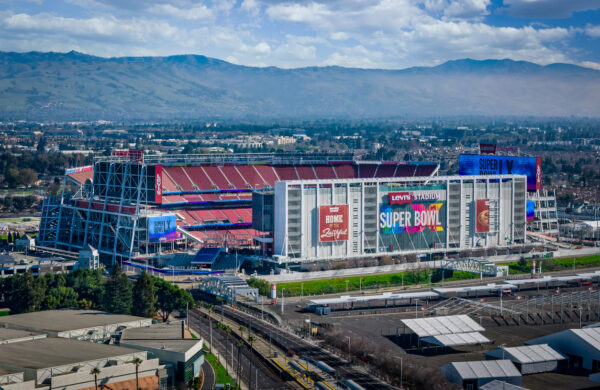 An aerial view of Levi's Stadium dressed for Super Bowl LX 2026 with a view of Santa Clara behind it.