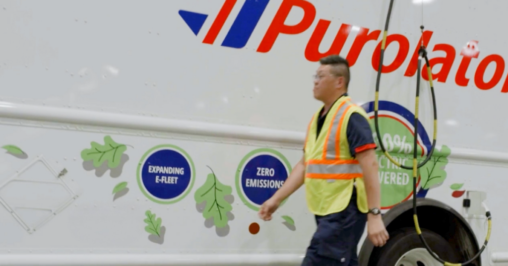 A person in front of a Purolator electric truck