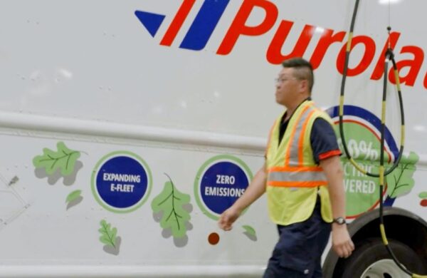 A person in front of a Purolator electric truck