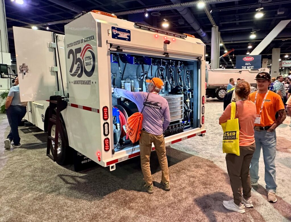 An attendee inspects the back of a work truck