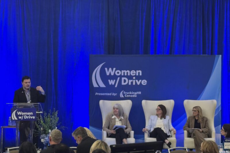 Three panelists and moderator on stage of WWD conference