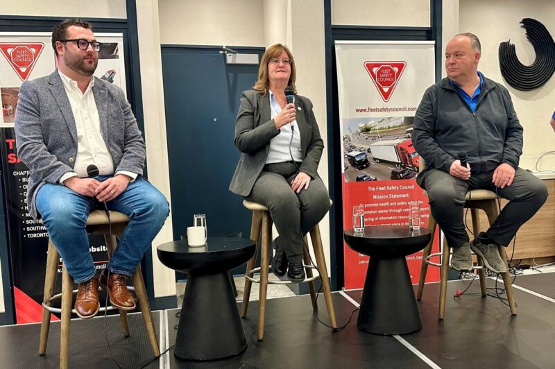 Picture of three people sitting on stage