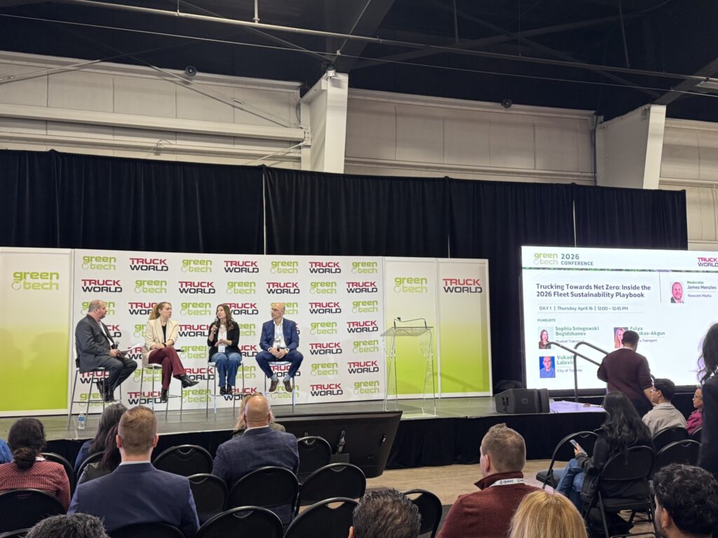 view from the back of the room, panelists on stage with people in attendance