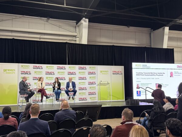 view from the back of the room, panelists on stage with people in attendance