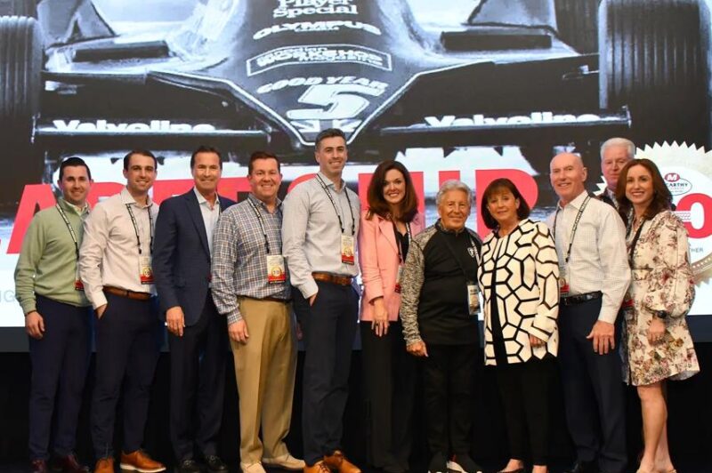 A group shot of a dozen people on stage during the celebration
