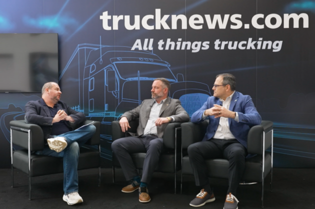 three people talking at trucknews.com booth