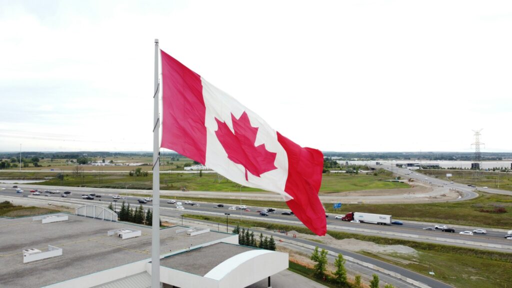 Canadian flag on a distribution centre with highway and trucks on the background