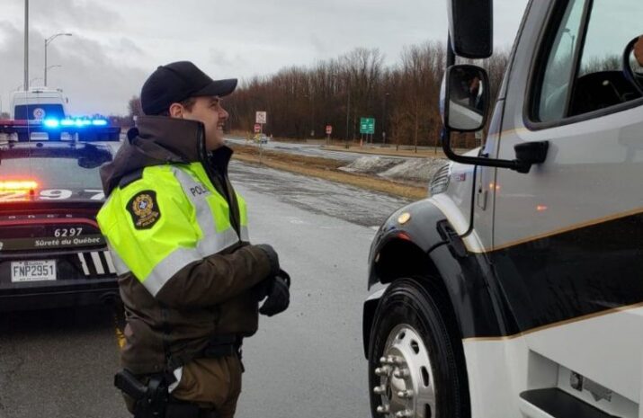 Police officer in Quebec talking to a truck driver in a cab
