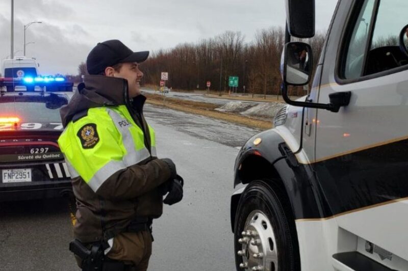 Police officer in Quebec talking to a truck driver in a cab