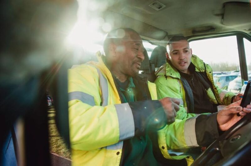Two driver sin a cab with a phone